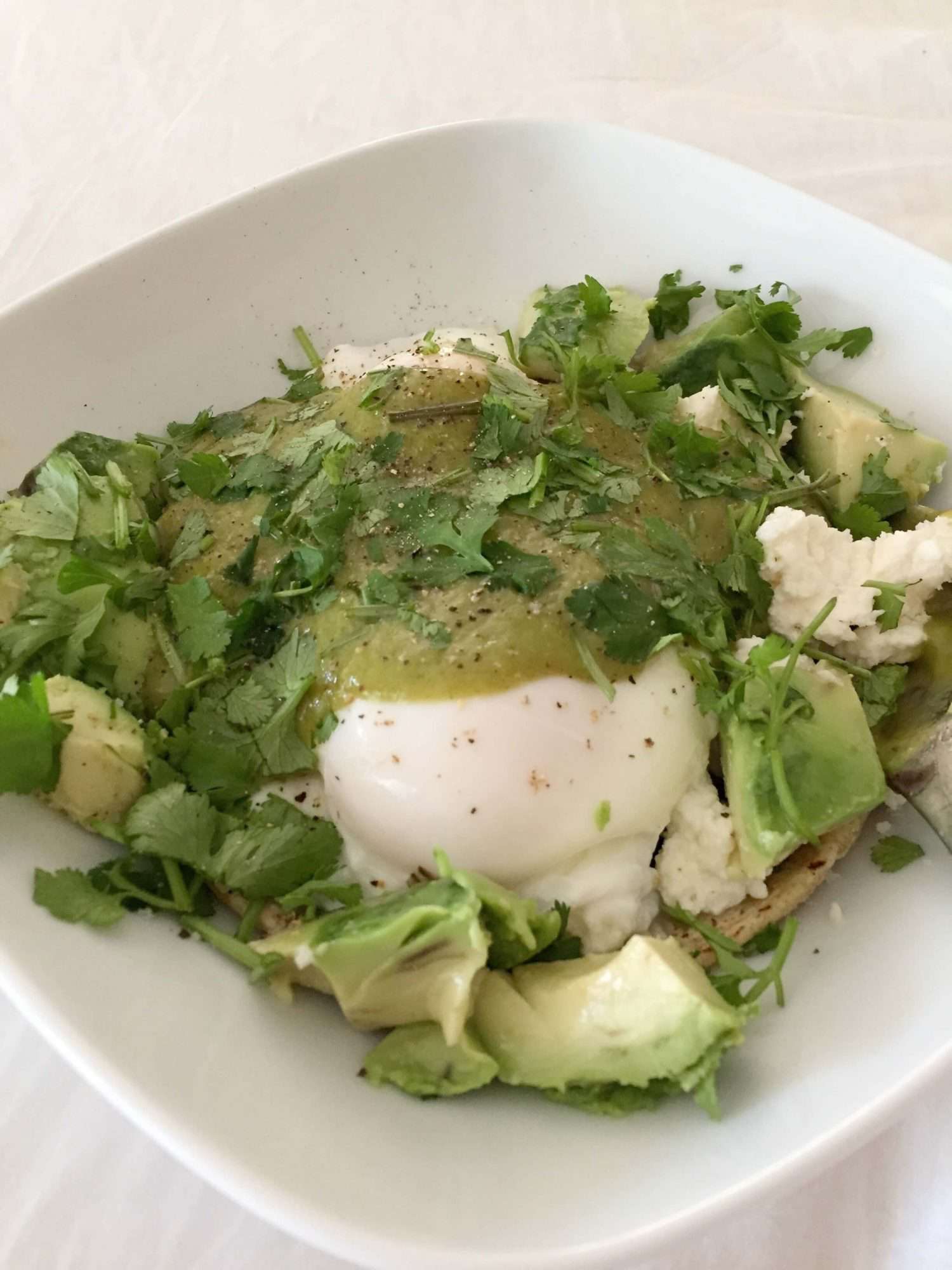Poached eggs swathed in green mole