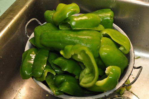 Chunked of green peppers in a colander.