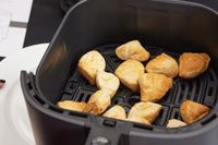Cooked frozen food ready inside of a Cosari air fryer.