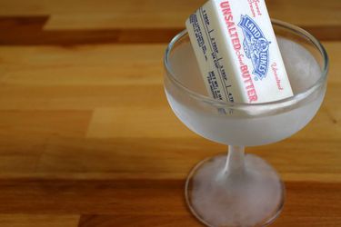 A stick of butter inside a chilled cocktail glass. 