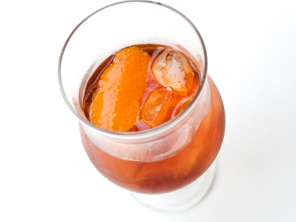 A Decolletage cocktail in a brandy snifter with orange peel. 