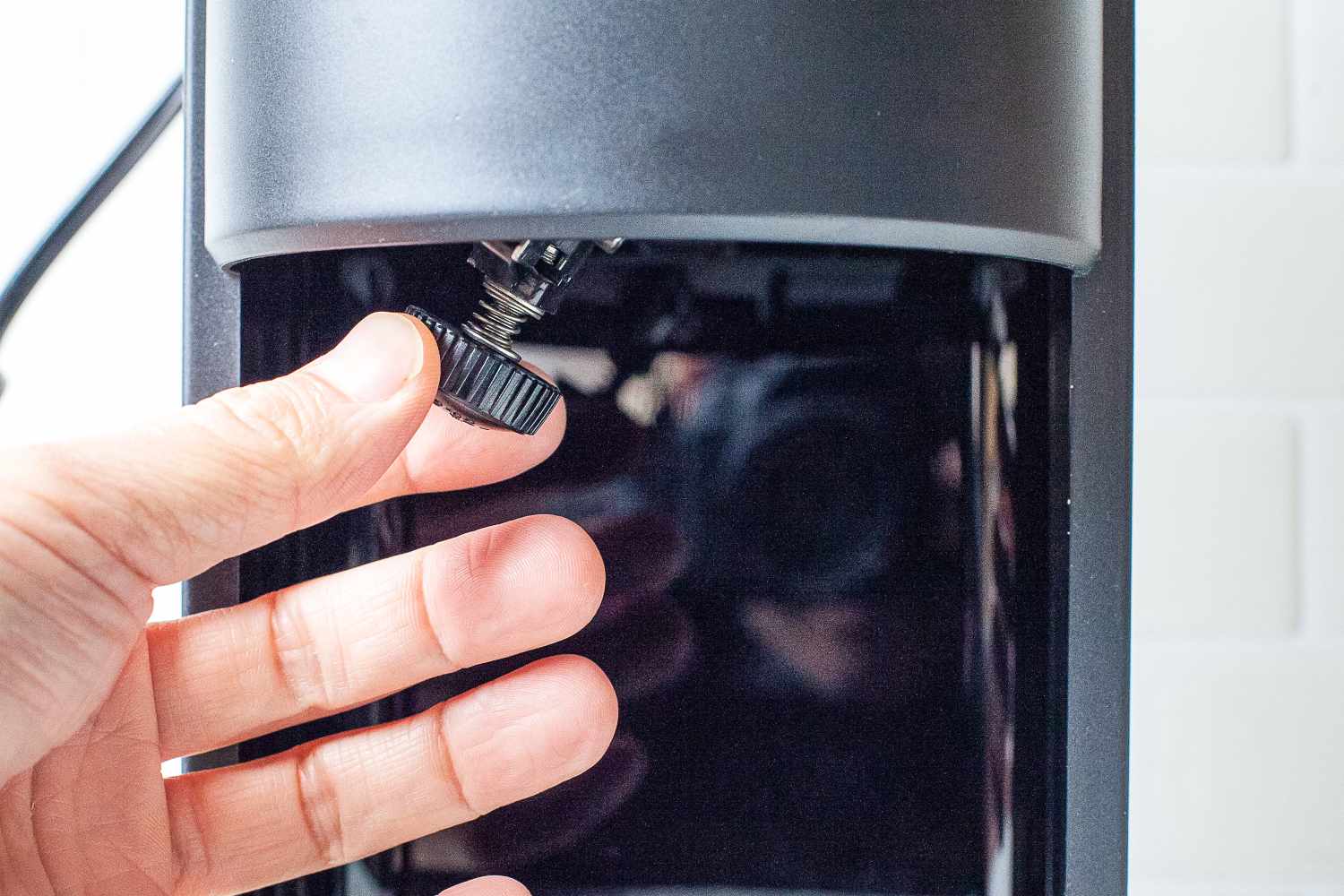 A hand adjusting a knob on Hawaiian Shaved Ice HomePro Shave Ice and Snow Cone Machine (S777)