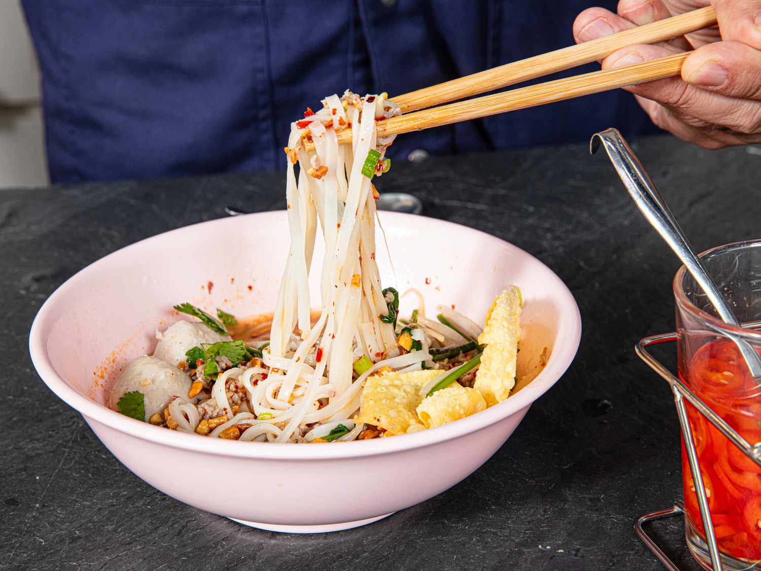 Side view of pulling noodles of tom yam 