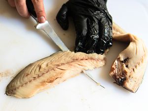 A person using the Wüsthof Classic Fish Fillet Knife to cut a fish