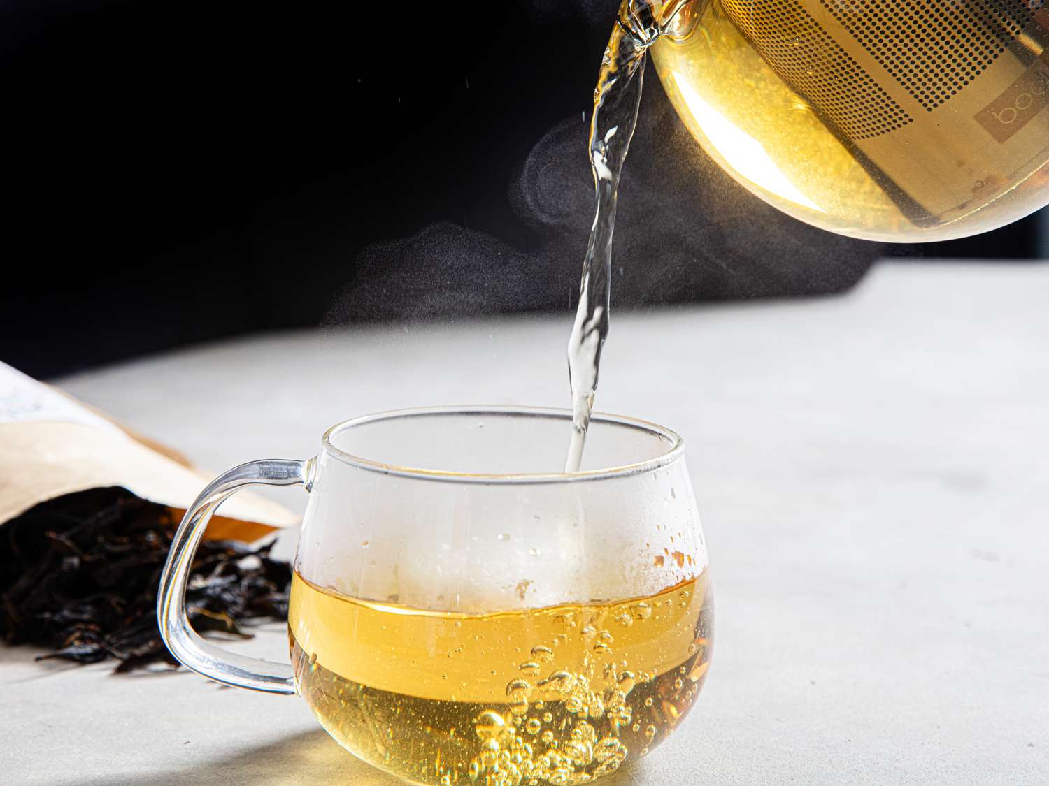 Tea going into a glass cup.