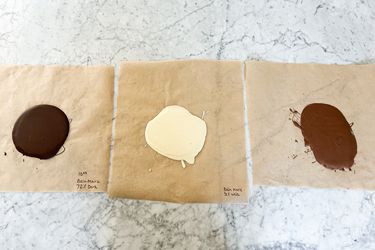 Three samples of melted chocolate on paper labeled with their respective descriptions