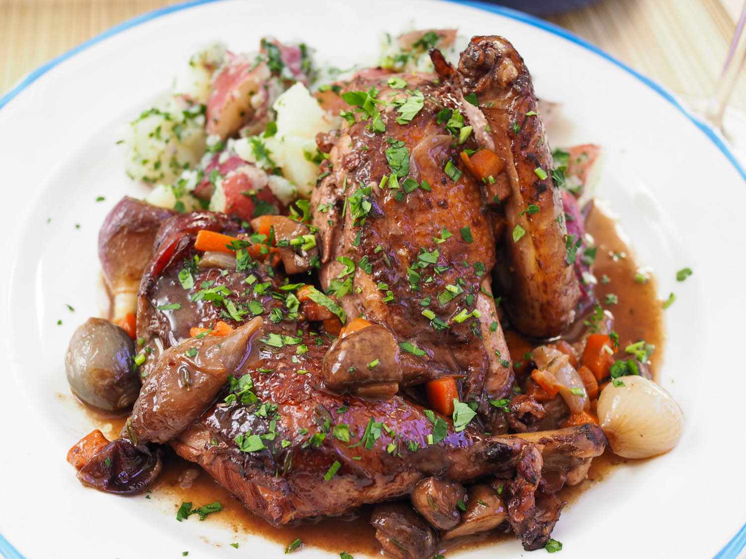 Finished, plated coq au vin, sprinkled with parsley.