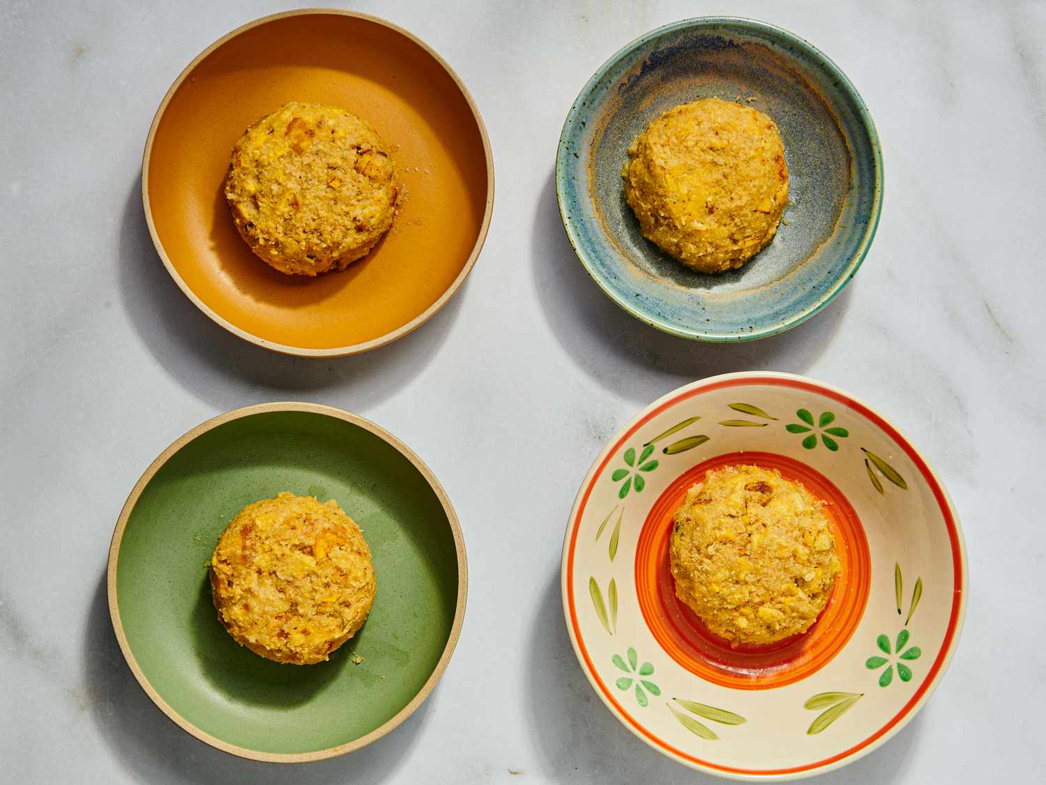 4 servings of mofongo on different colored dishes 