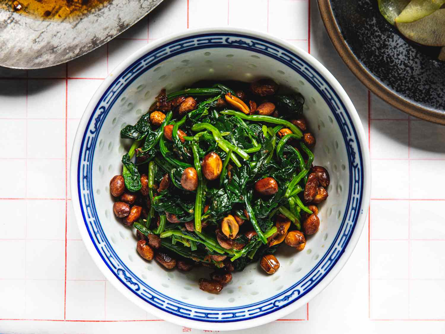 Plated Peanuts and Spinach dish in a white bowl with a blue rim