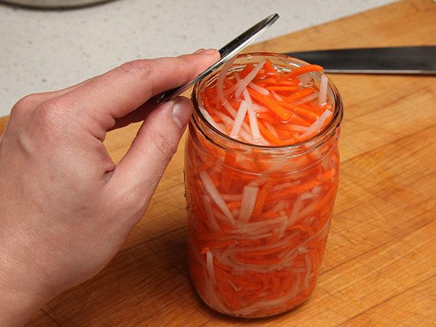 Opening up a jar of pickled daikon and carrot.