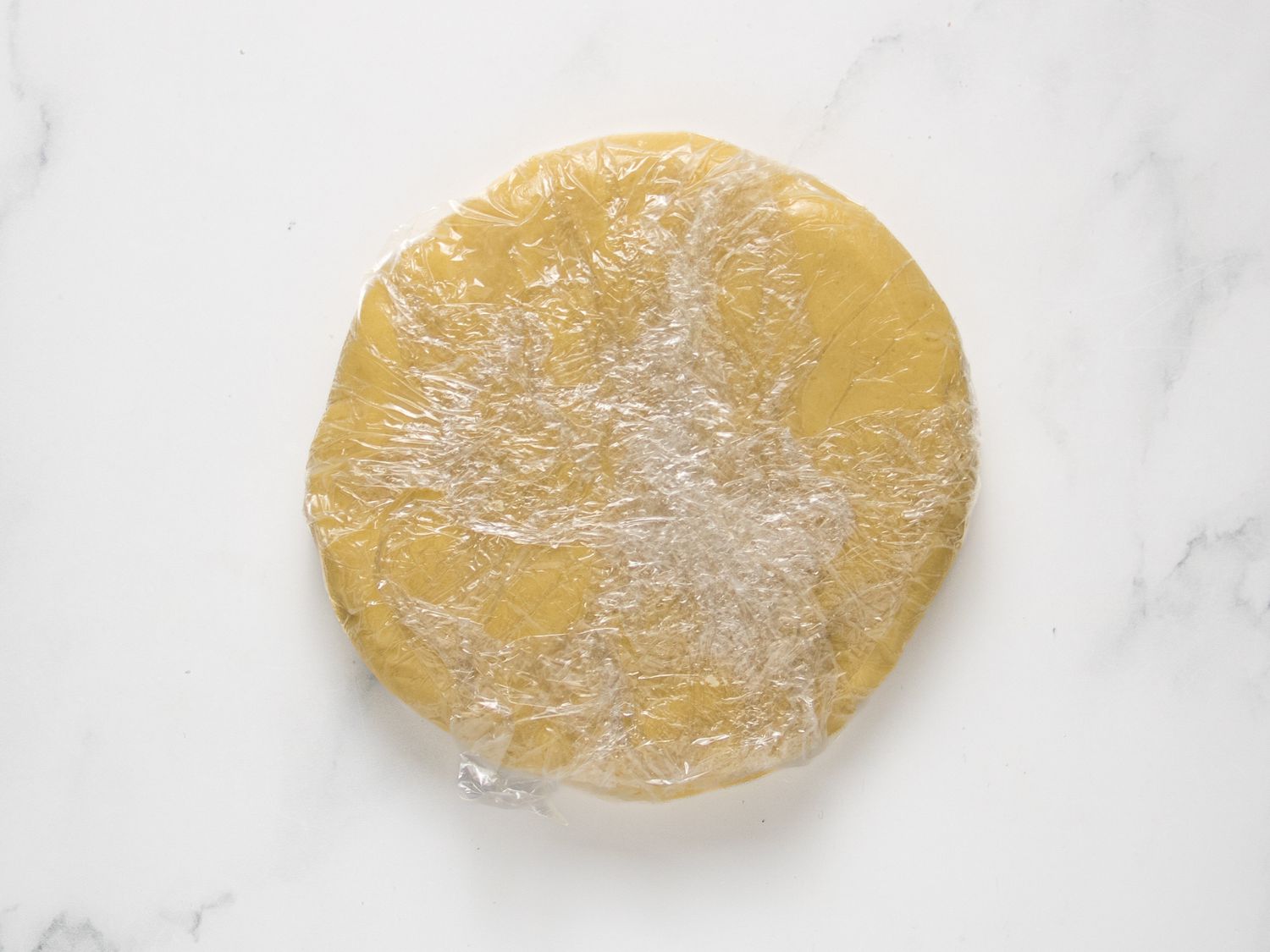 Dough wrapped tightly in plastic wrap 