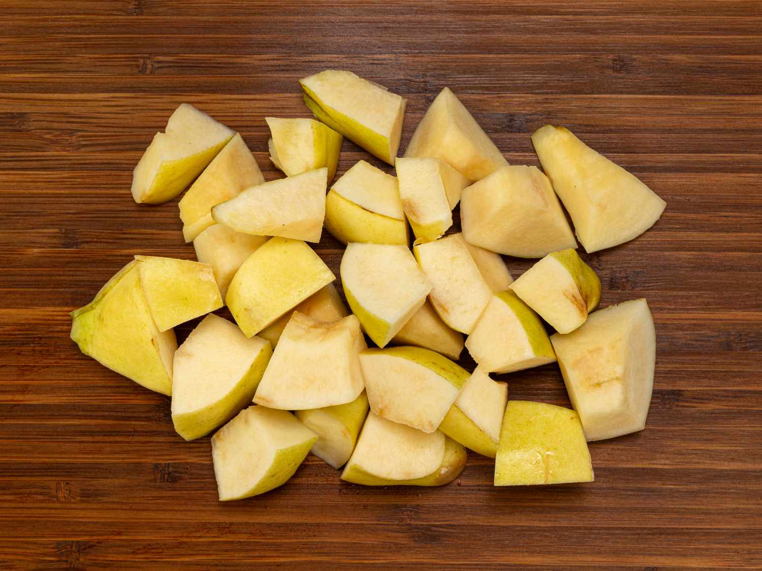 Chopped quince pieces on a wooden cutting board