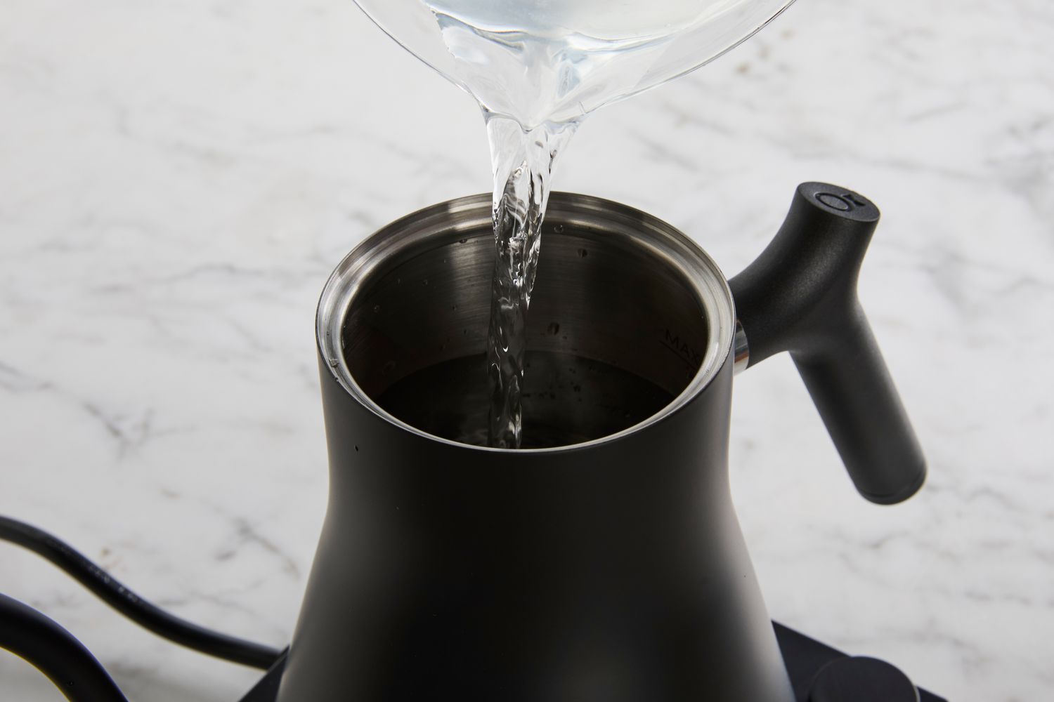 Person pouring water into Fellow Stagg EKG Electric Gooseneck Kettle