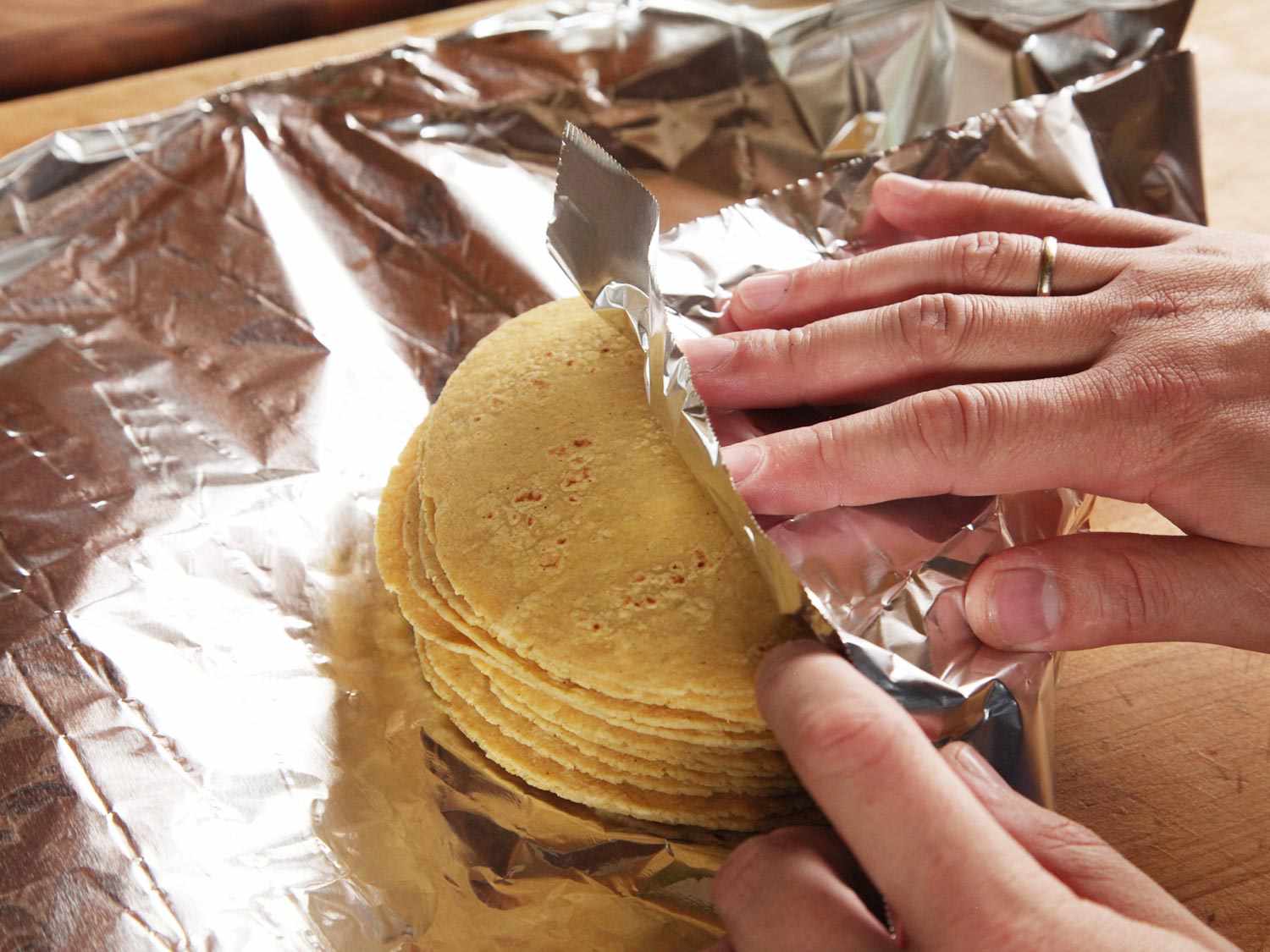 A stack of corn tortillas are wrapped in foil.