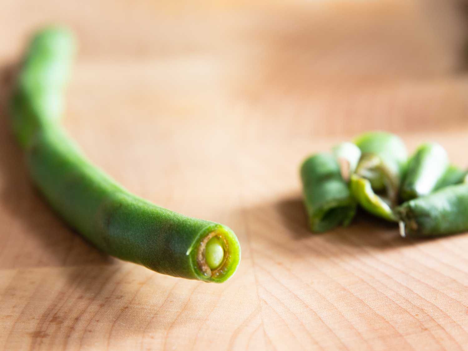 A green bean that has begun to rot on the inside, and is not worth saving.