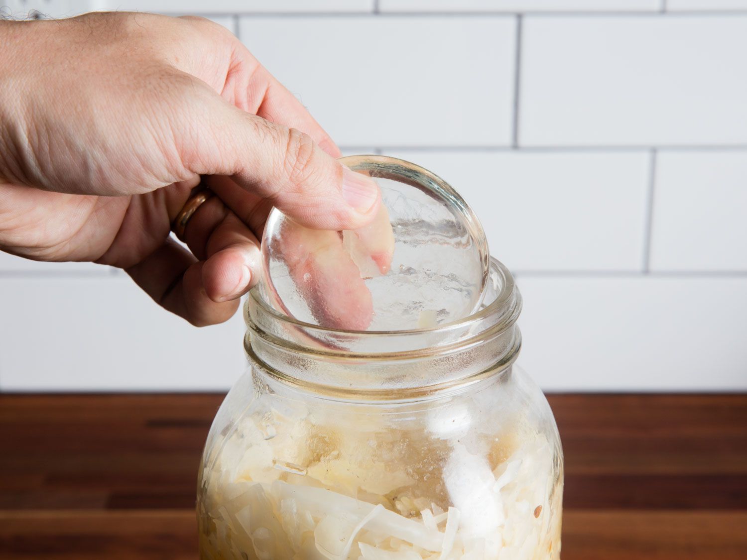 Weight Being Dropped on Sauerkraut in Mason Jar