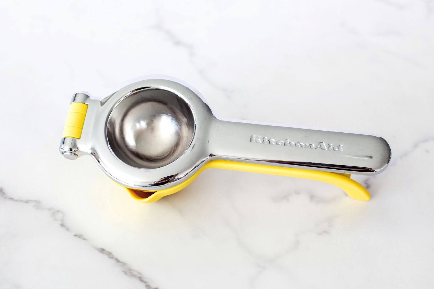 The KitchenAid citrus juicer on a marble countertop.