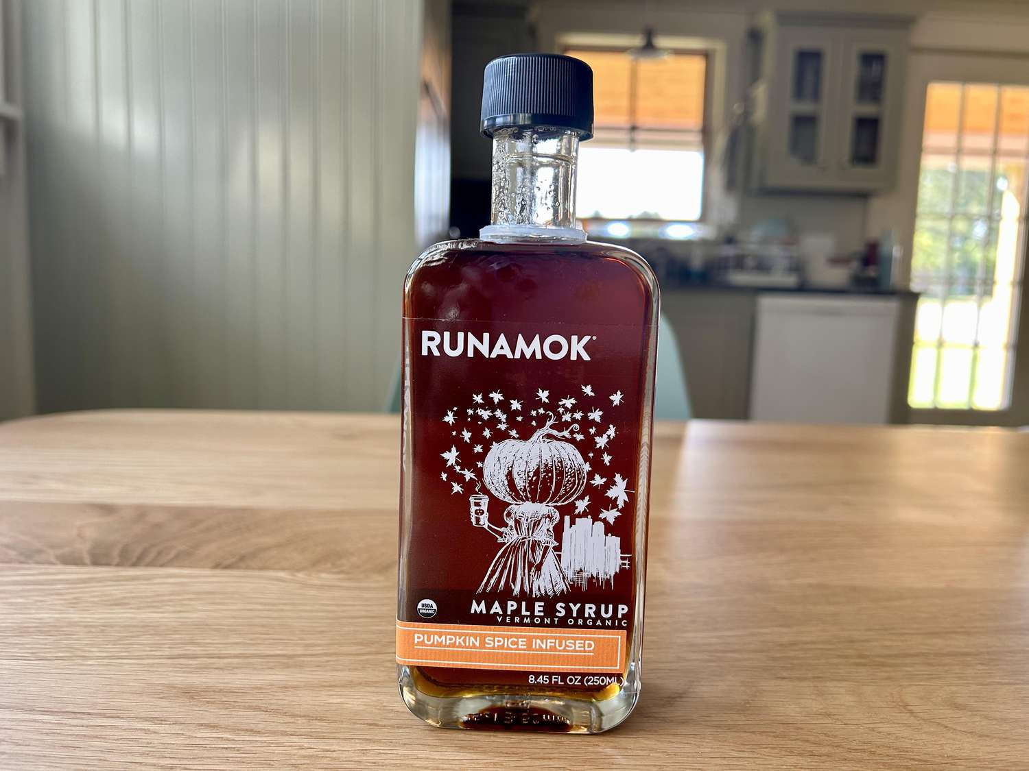 A bottle of Runamok Pumpkin Spice maple syrup on a kitchen table