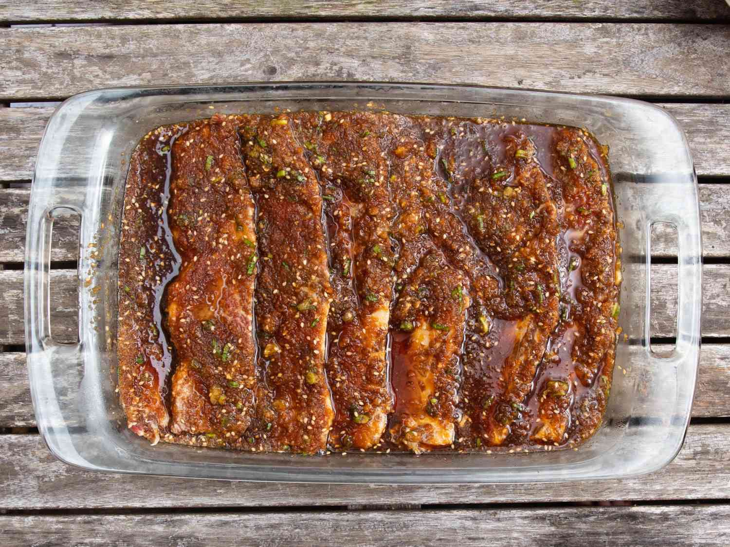 Beef galbi marinating in a glass casserole dish.