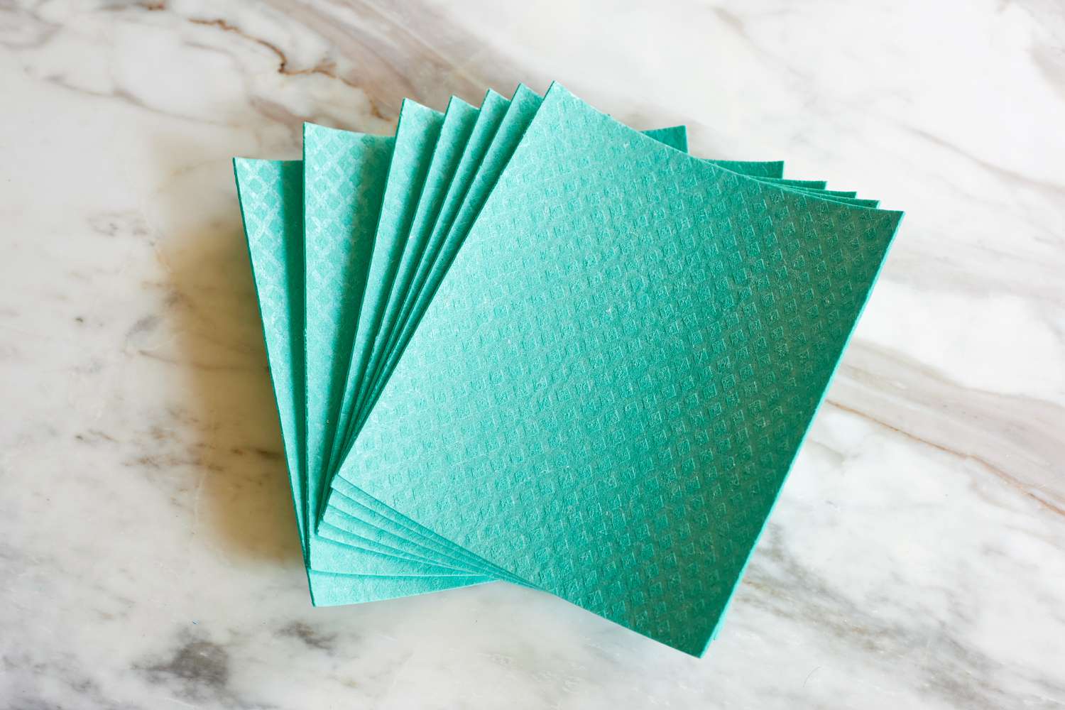 a stack of blue swedish dishcloths on a marble surface