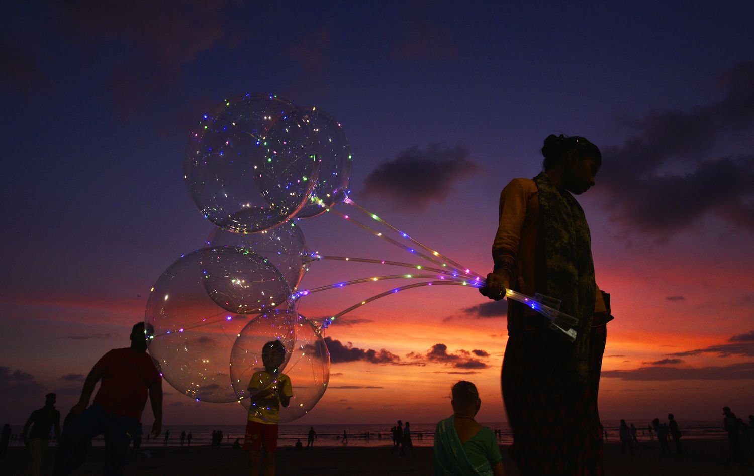 A woman selling clear balloons at Juhu Beach