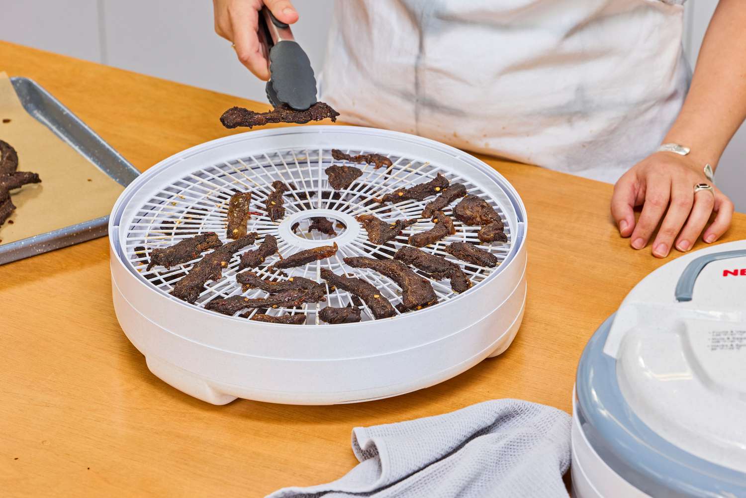 A person taking out the food samples from Nesco Snackmaster Pro Food Dehydrator