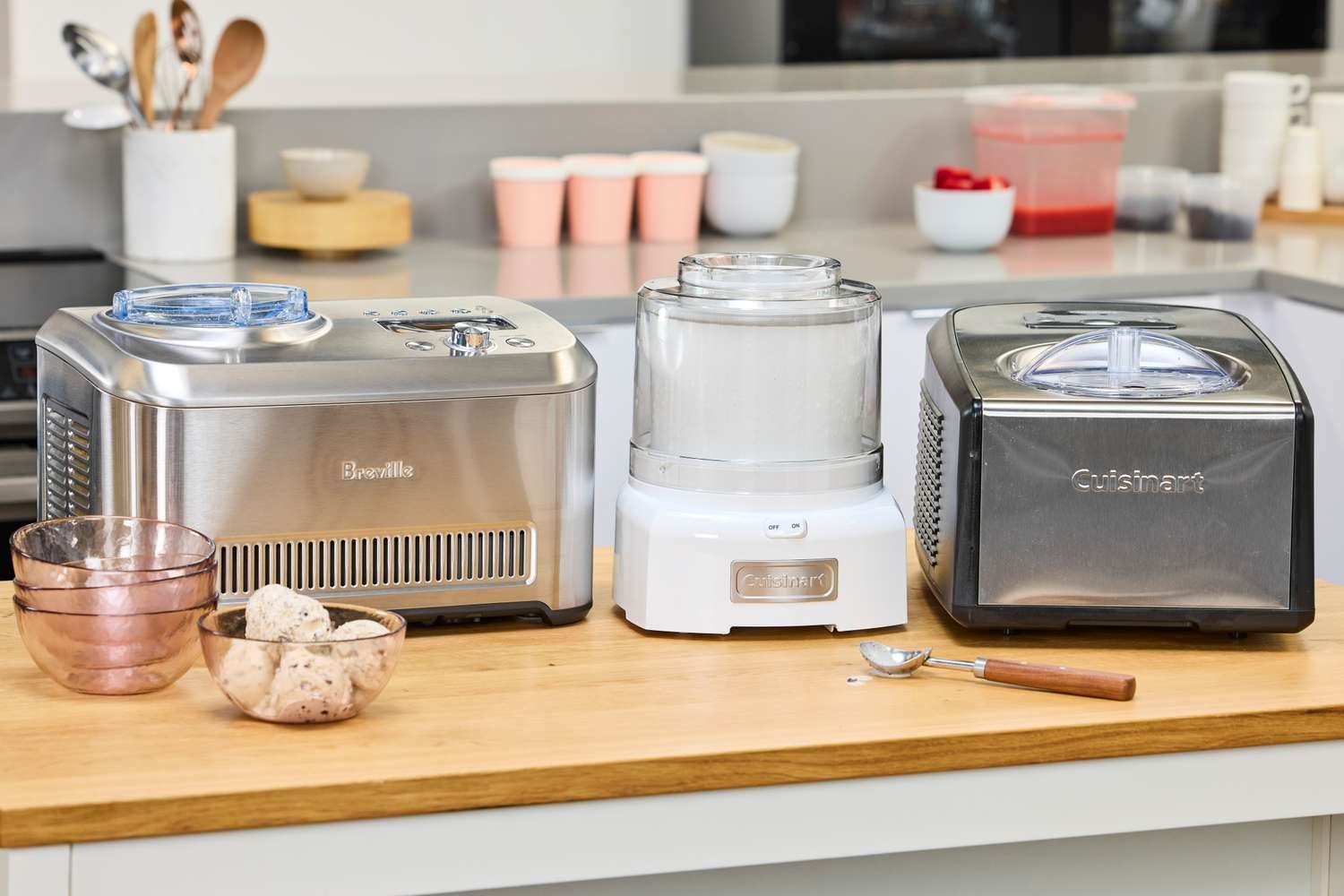 Three ice cream makers on a kitchen counter.