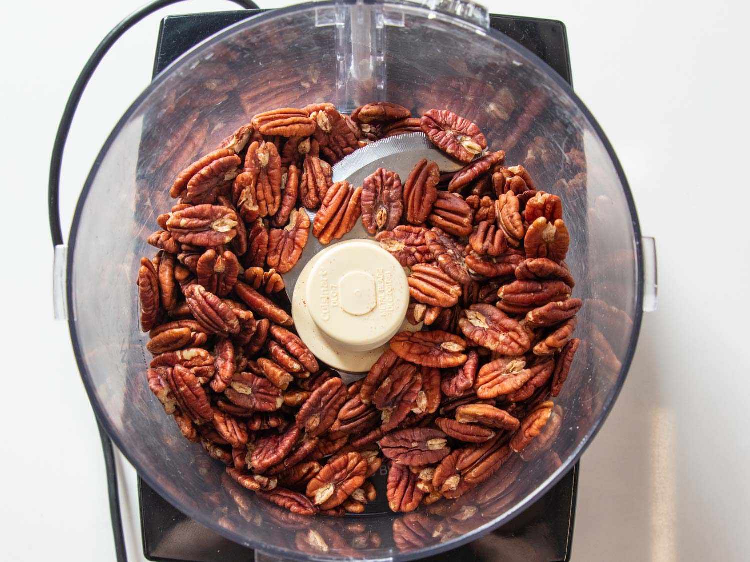 Pecans in a food processor, before being processed.