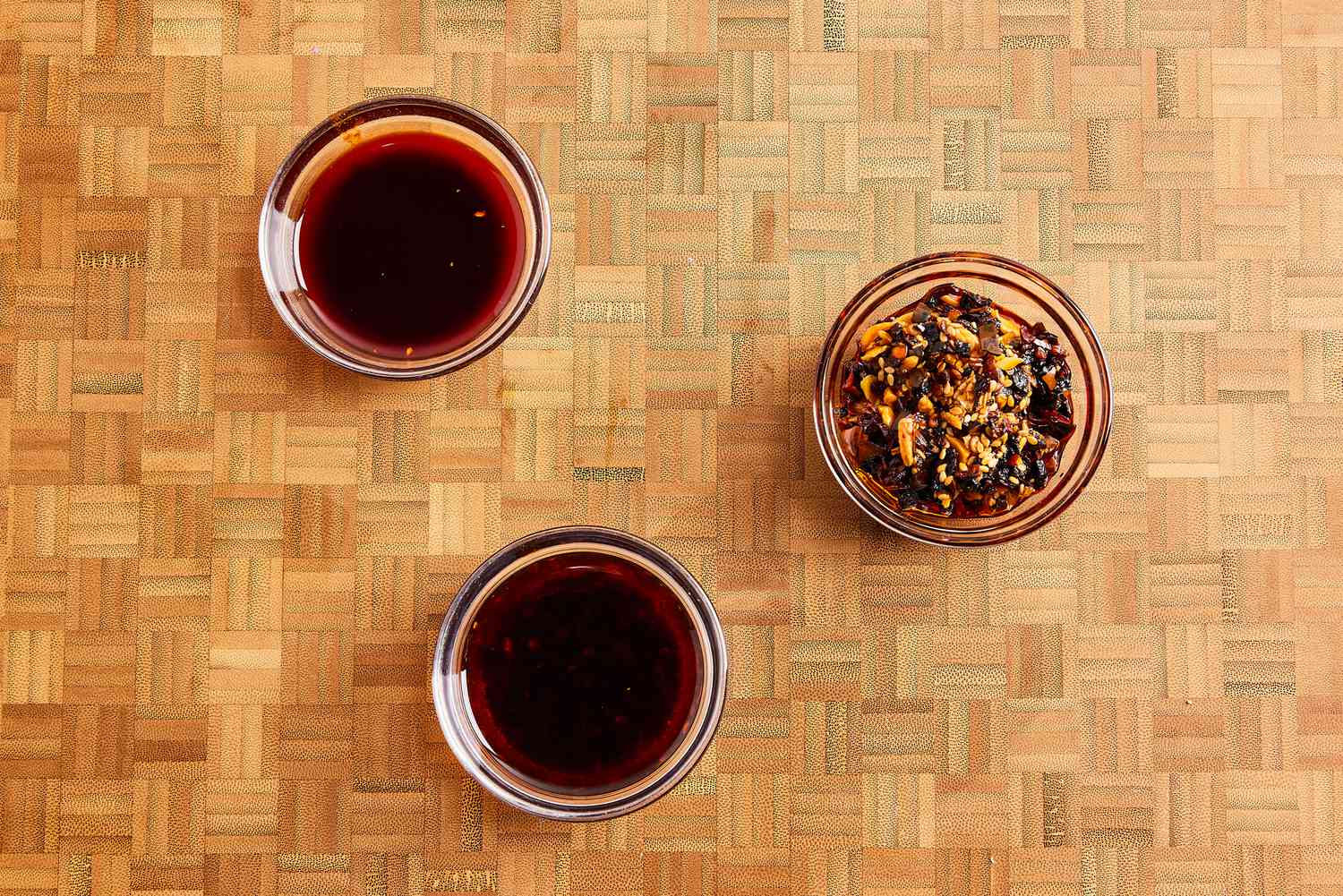 Three types of chili crisp in small bowls.