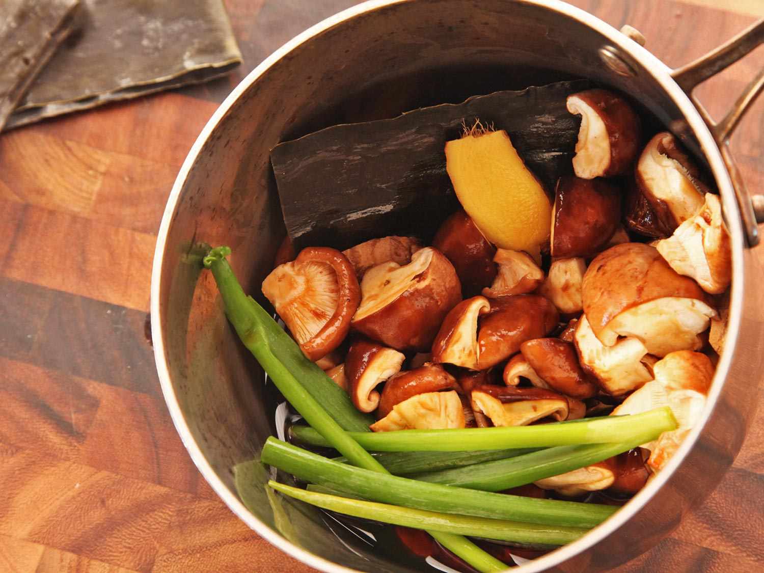 Kombu, mushrooms, scallions, and ginger in a saucepan to simmer for creamy vegan ramen tare.