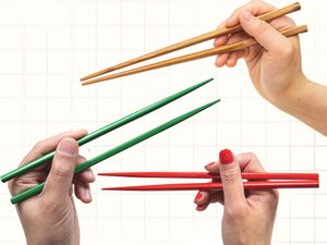 Four hands holding chopsticks in different positions