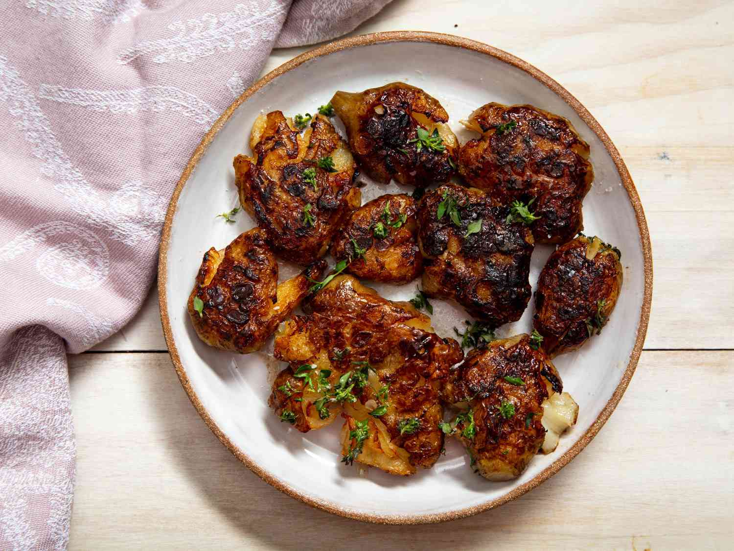Smashed cooked sunchokes resting on a plate. 