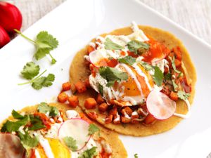 Sweet potato tacos topped with fried egg and drizzled with crema