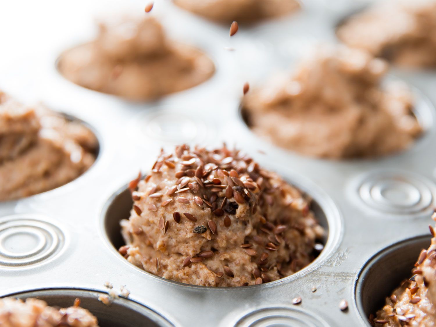 Unbaked bran muffin batter in muffin pan.