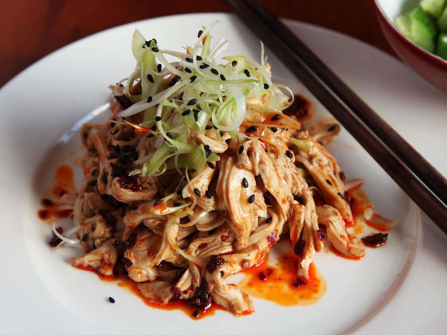 Plated Sichuan chicken salad drizzled with chile oil.