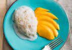 Overhead of coconut sticky rice on a plate with slices of mango