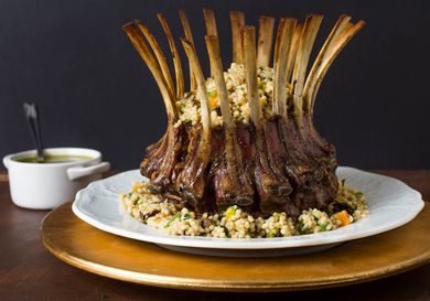 A roasted rack of lamb topped with couscous stuffing.