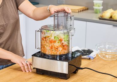 A person chops vegetables in the Cuisinart 14-Cup Food Processor