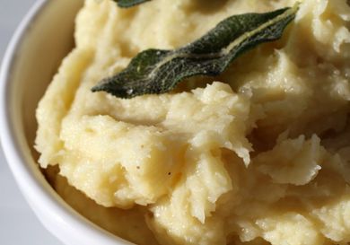 A bowl of parsnip puree with olive oil and sage. 