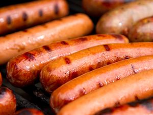 Closeup of grilled hot dogs and sausages on a grill