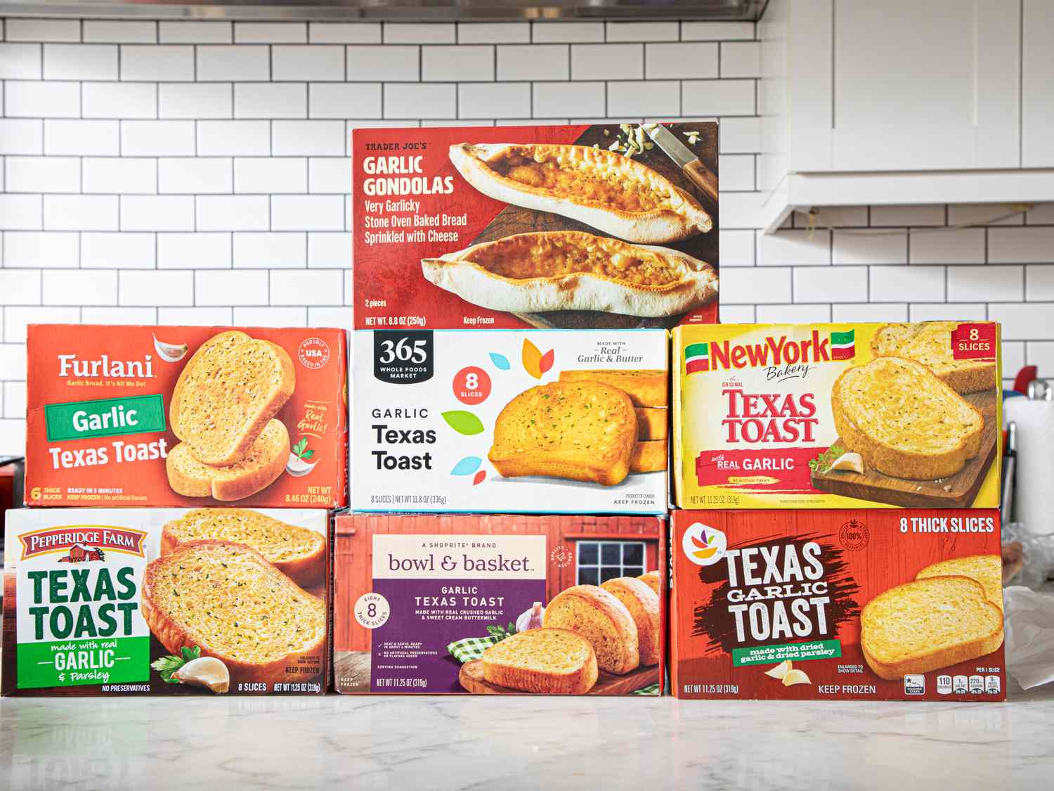 Various packaged brands of garlic bread and Texas toast displayed on a counter