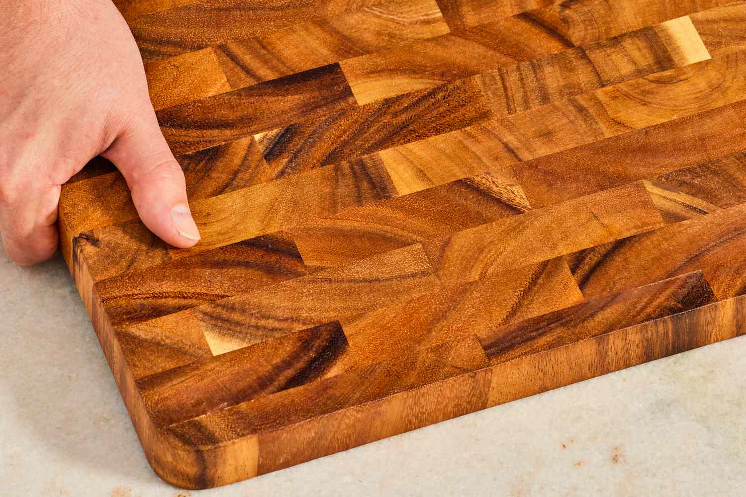 A person holds a wooden cutting board
