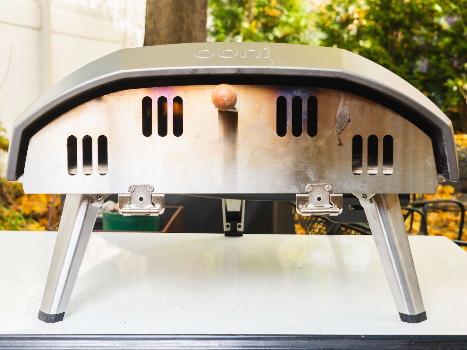 An outdoor pizza oven fitted with an oven door to speed up preheating