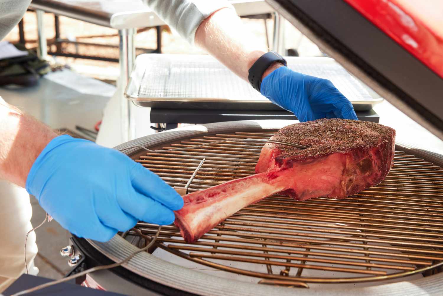 a person setting a steak onto the Konnected Joe's grates