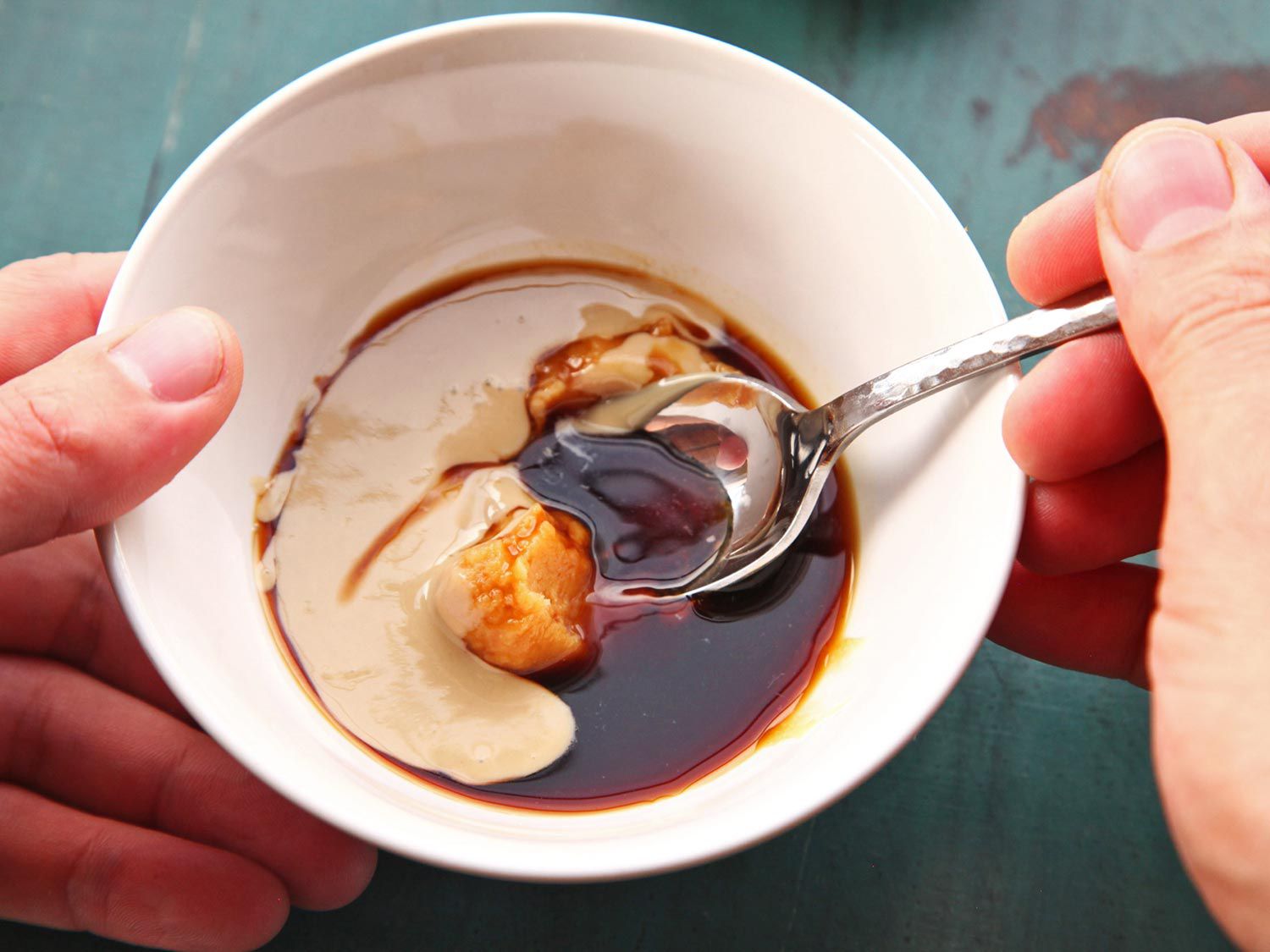 Vegan ramen tare stirred together in a white bowl with miso and sesame pastes.
