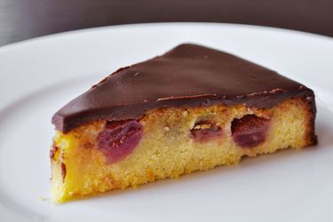 Closeup of a slice of Olive Oil Cake With Roasted Grapes and Ganache