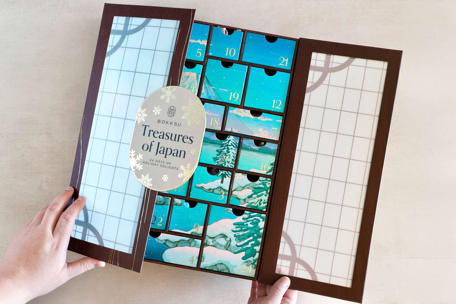Opened advent calendar with the title Treasures of Japan on it displaying compartments featuring artwork inspired by winter scenes
