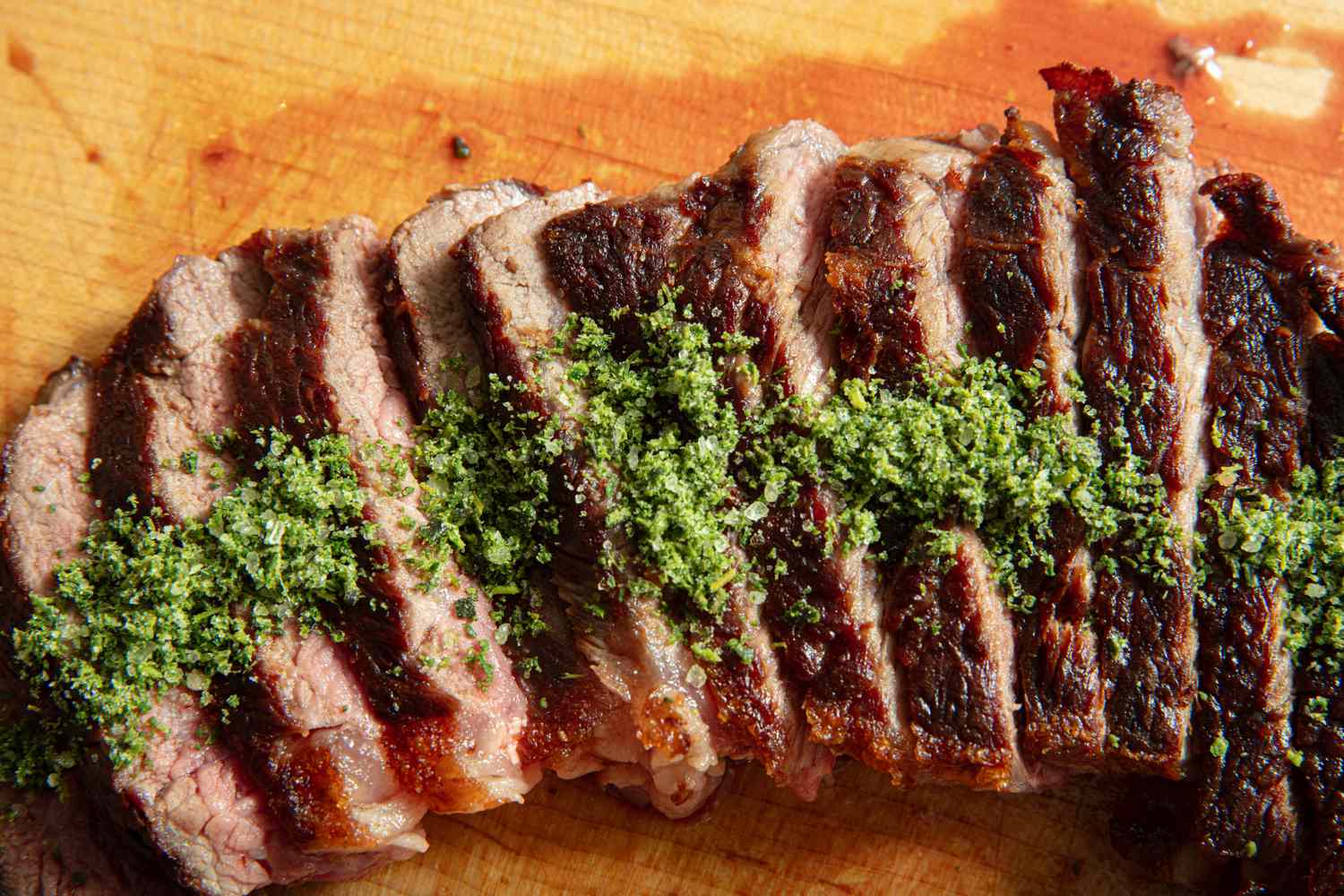 Sliced grilled steak topped with a green herb mixture