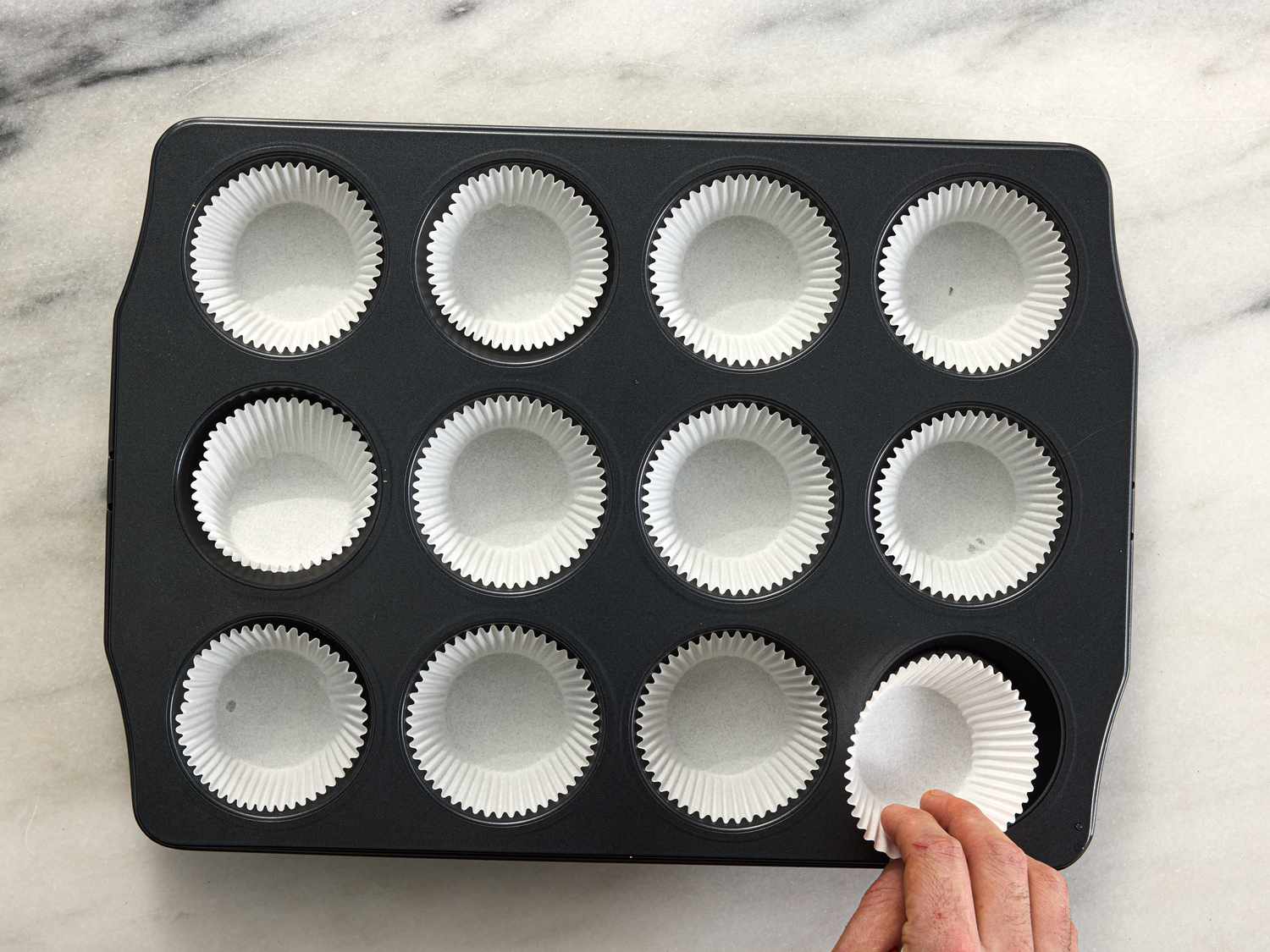 Overhead view of lining muffin tins