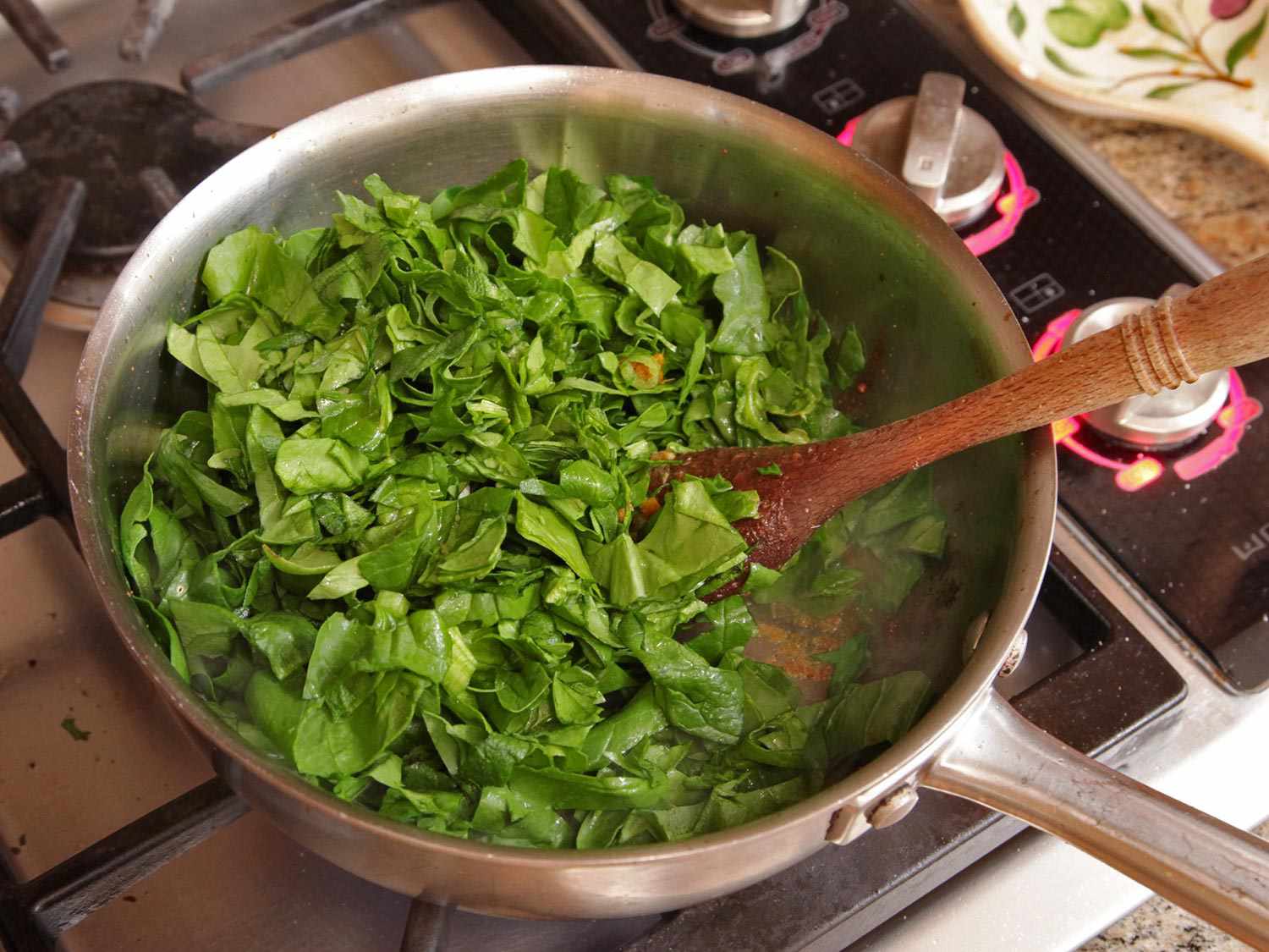 Chopped fresh spinach is added to the pan.